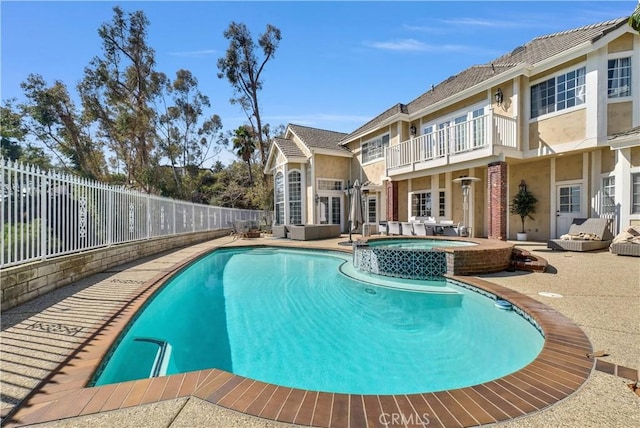 view of swimming pool featuring a fenced backyard, a pool with connected hot tub, and a patio