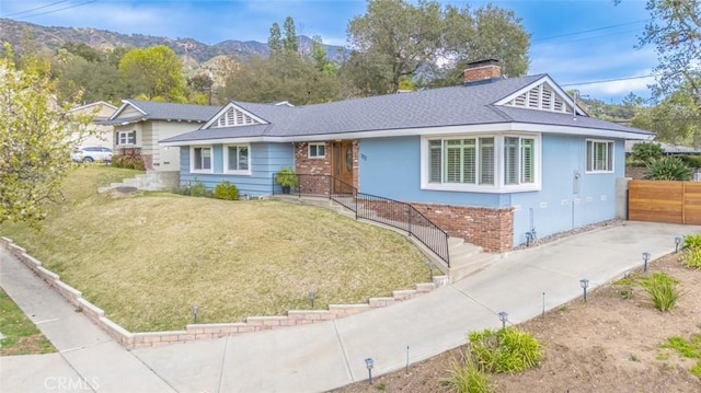 ranch-style home featuring a mountain view and a front lawn