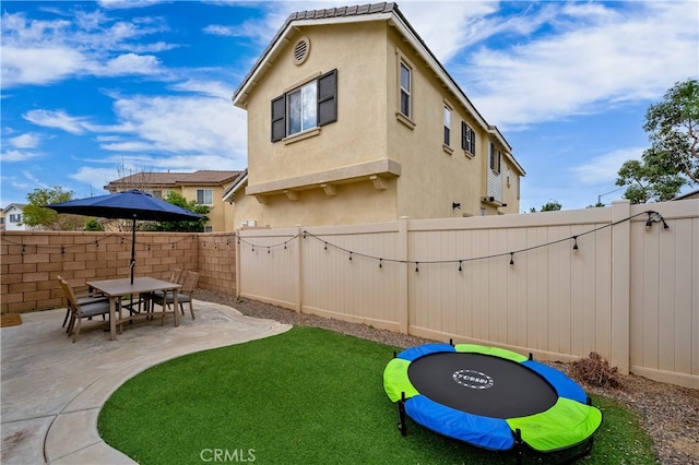 view of yard featuring a patio and a trampoline