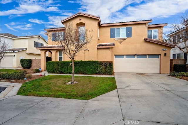 mediterranean / spanish house with a garage and a front yard