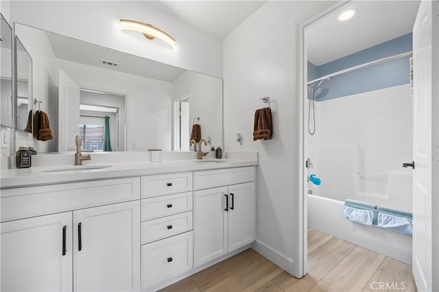 bathroom featuring shower / tub combination, wood-type flooring, and vanity