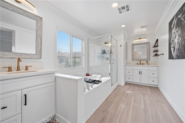 bathroom featuring ornamental molding, shower with separate bathtub, hardwood / wood-style floors, and vanity