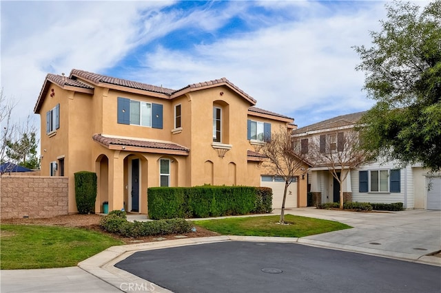 mediterranean / spanish-style home with a garage and a front lawn