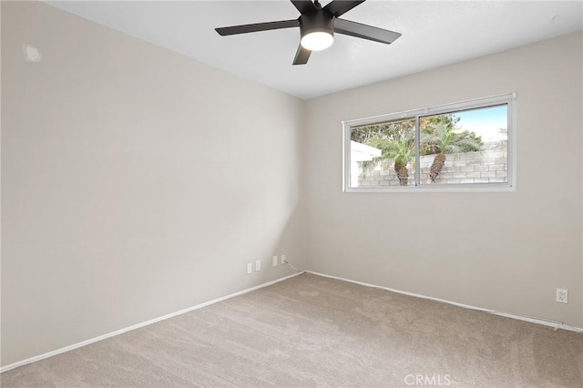 spare room featuring light colored carpet and ceiling fan