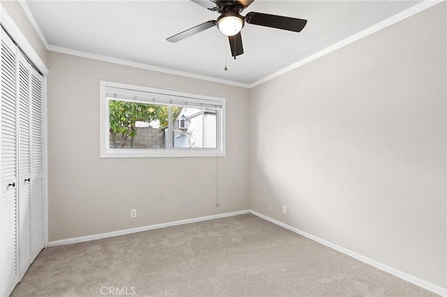 unfurnished bedroom with ceiling fan, ornamental molding, light carpet, and a closet