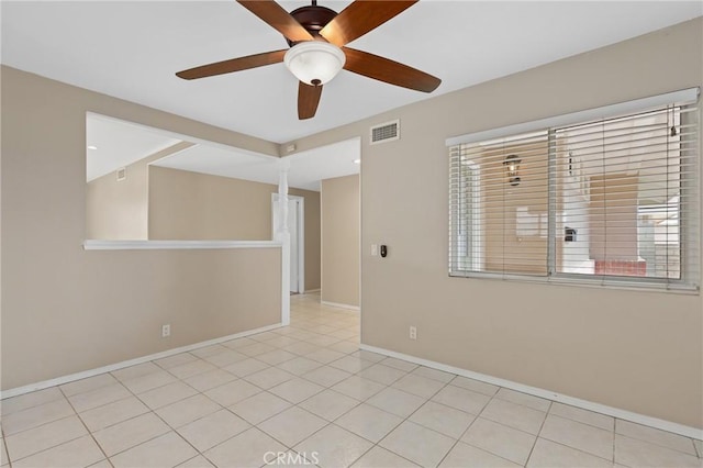 tiled empty room featuring ceiling fan and decorative columns