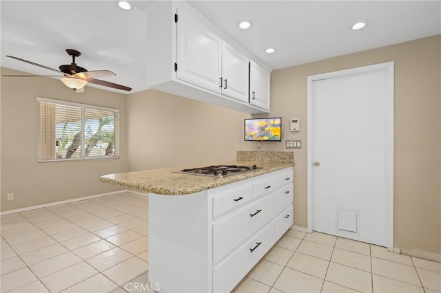 kitchen featuring light tile patterned flooring, white cabinetry, kitchen peninsula, ceiling fan, and stainless steel gas stovetop