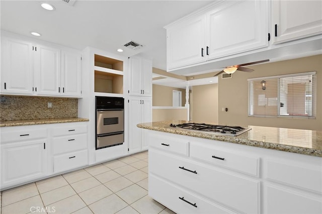 kitchen featuring light stone counters, light tile patterned floors, white cabinets, and appliances with stainless steel finishes