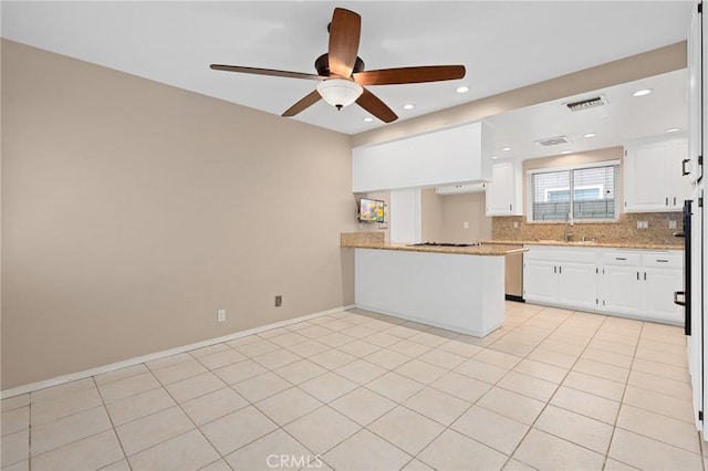 kitchen with sink, light tile patterned floors, kitchen peninsula, white cabinets, and backsplash