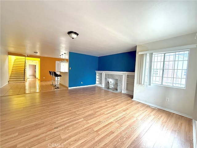 unfurnished living room with a fireplace and light hardwood / wood-style flooring