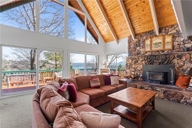 carpeted living room featuring beamed ceiling, a wood stove, wooden ceiling, and high vaulted ceiling