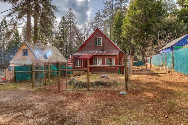 exterior space featuring metal roof and fence