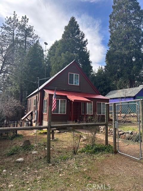 view of front of home with metal roof, a fenced front yard, and a gate