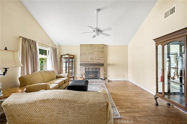 living room featuring hardwood / wood-style floors, a fireplace, high vaulted ceiling, and ceiling fan