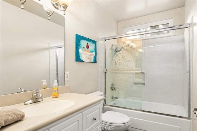 full bathroom with enclosed tub / shower combo, vanity, and toilet