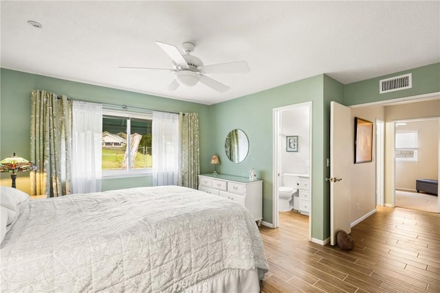 bedroom featuring ensuite bath, light hardwood / wood-style flooring, and ceiling fan