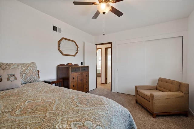 bedroom with ceiling fan, a closet, and light carpet