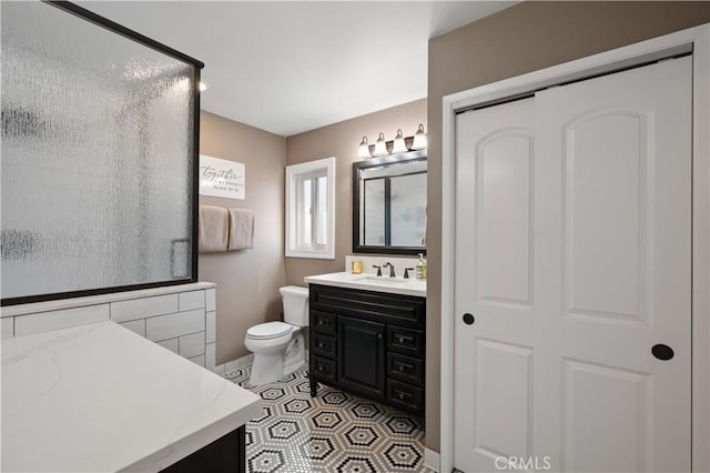 bathroom featuring vanity, tile patterned floors, and toilet