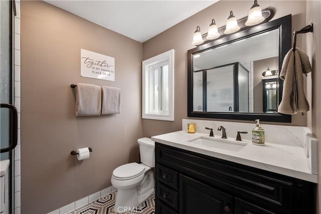 bathroom featuring tile patterned flooring, vanity, an enclosed shower, and toilet