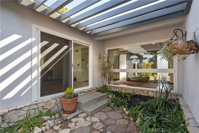 view of exterior entry featuring a pergola