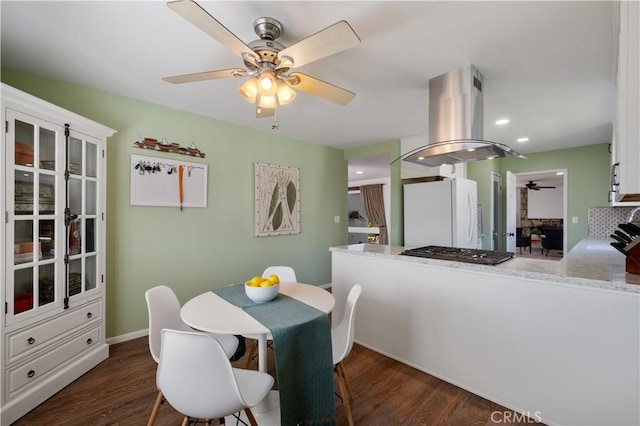 dining area with dark wood-type flooring and ceiling fan