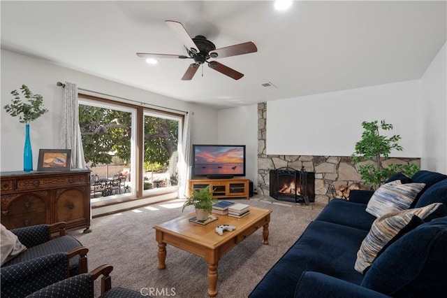 living room featuring light carpet, a fireplace, and ceiling fan