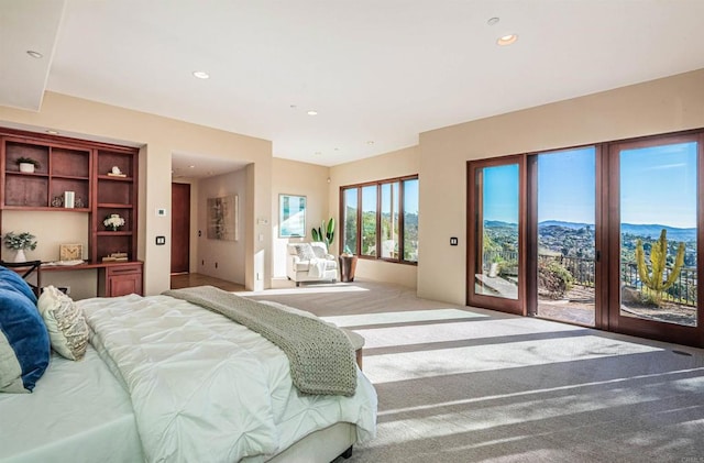 carpeted bedroom featuring a mountain view and access to exterior