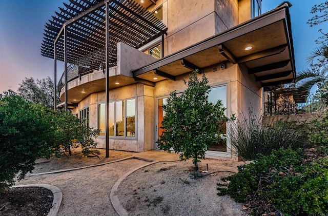 exterior space featuring a balcony and a pergola