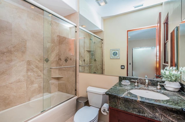 full bathroom with shower / bath combination with glass door, vanity, and toilet