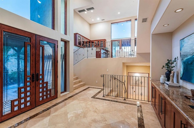 entrance foyer featuring a towering ceiling and french doors