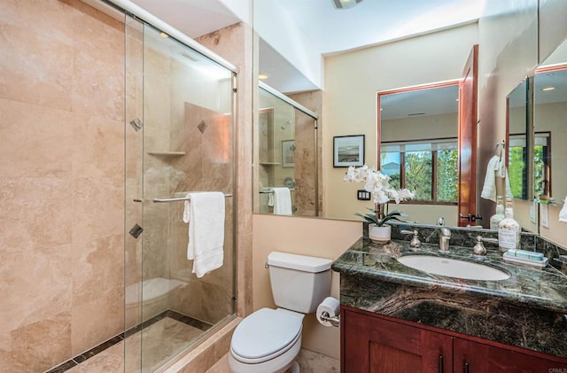 bathroom with vanity, toilet, and a shower with shower door