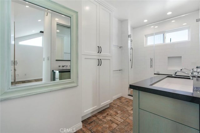 bathroom with vanity and a shower with door