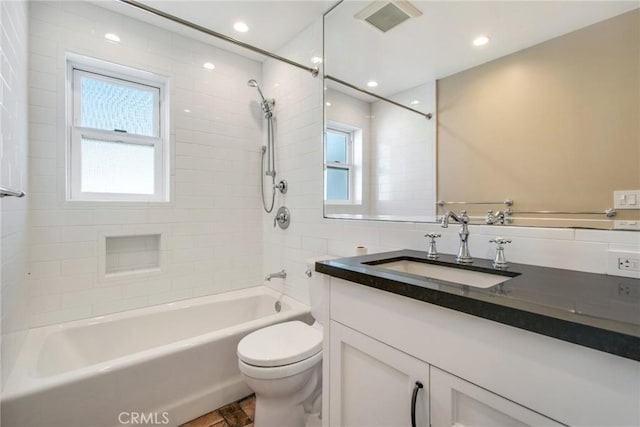 full bathroom with tiled shower / bath, a healthy amount of sunlight, toilet, and vanity