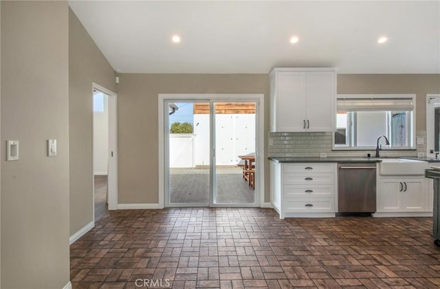 kitchen featuring white cabinetry, backsplash, plenty of natural light, and stainless steel dishwasher