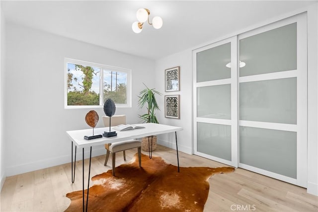 home office with light hardwood / wood-style flooring