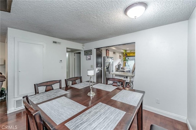 dining space with a textured ceiling and dark hardwood / wood-style flooring