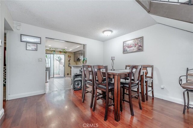 dining area featuring hardwood / wood-style flooring and a textured ceiling