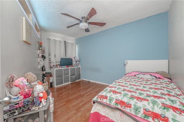 bedroom featuring wood-type flooring, ceiling fan, and a textured ceiling