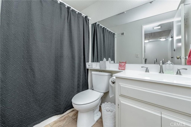 bathroom with vanity, tile patterned floors, and toilet