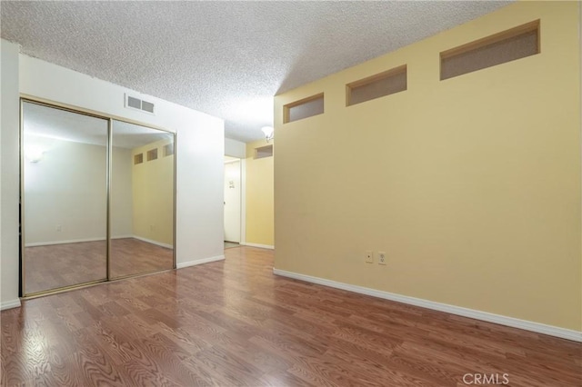 unfurnished bedroom with wood-type flooring and a textured ceiling