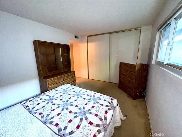 bedroom featuring light colored carpet and a closet