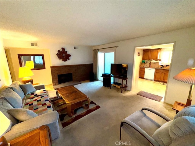 living room featuring a brick fireplace, light colored carpet, and a textured ceiling