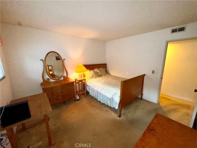 bedroom with carpet floors and a textured ceiling