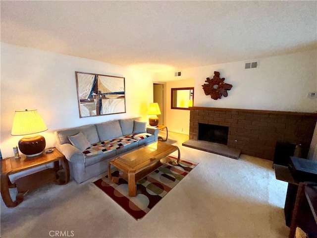 living room featuring a brick fireplace, light carpet, and a textured ceiling