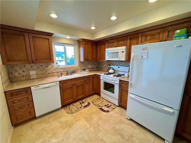 kitchen featuring sink, white appliances, light tile patterned floors, and backsplash