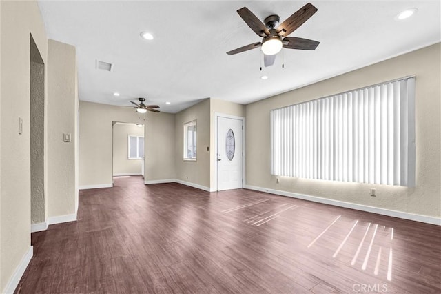 unfurnished living room featuring ceiling fan and dark hardwood / wood-style flooring