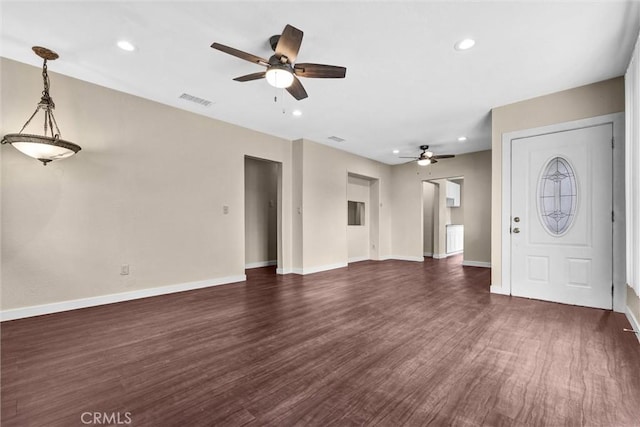 unfurnished living room with dark hardwood / wood-style flooring and ceiling fan