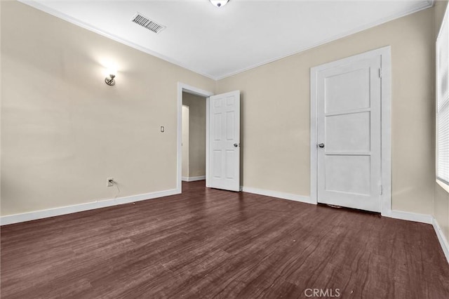 unfurnished bedroom with ornamental molding and dark wood-type flooring