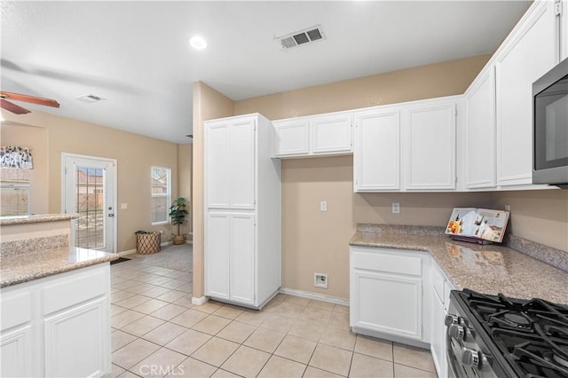 kitchen featuring light tile patterned flooring, appliances with stainless steel finishes, white cabinets, and ceiling fan