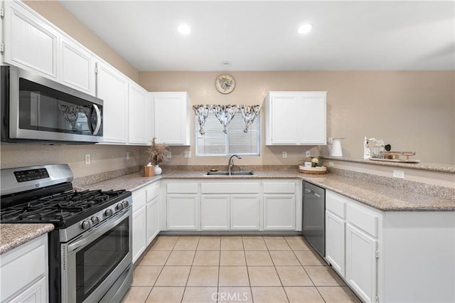 kitchen featuring sink, appliances with stainless steel finishes, white cabinetry, light stone counters, and light tile patterned flooring